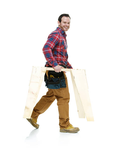 Smiling carpenter walking and looking at camera Smiling carpenter walking and looking at camerahttp://www.twodozendesign.info/i/1.png sawhorse stock pictures, royalty-free photos & images