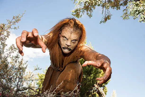 A human Lion creature reaches out menacingly to grab you.  Looking into the camera.  Character created by renowned special fx make-up artist Rayce Bird.