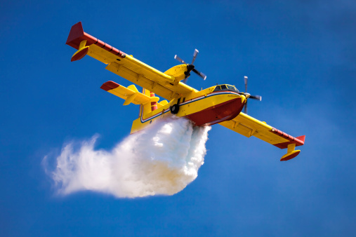 A twin-engined water bomber dumping water in the air