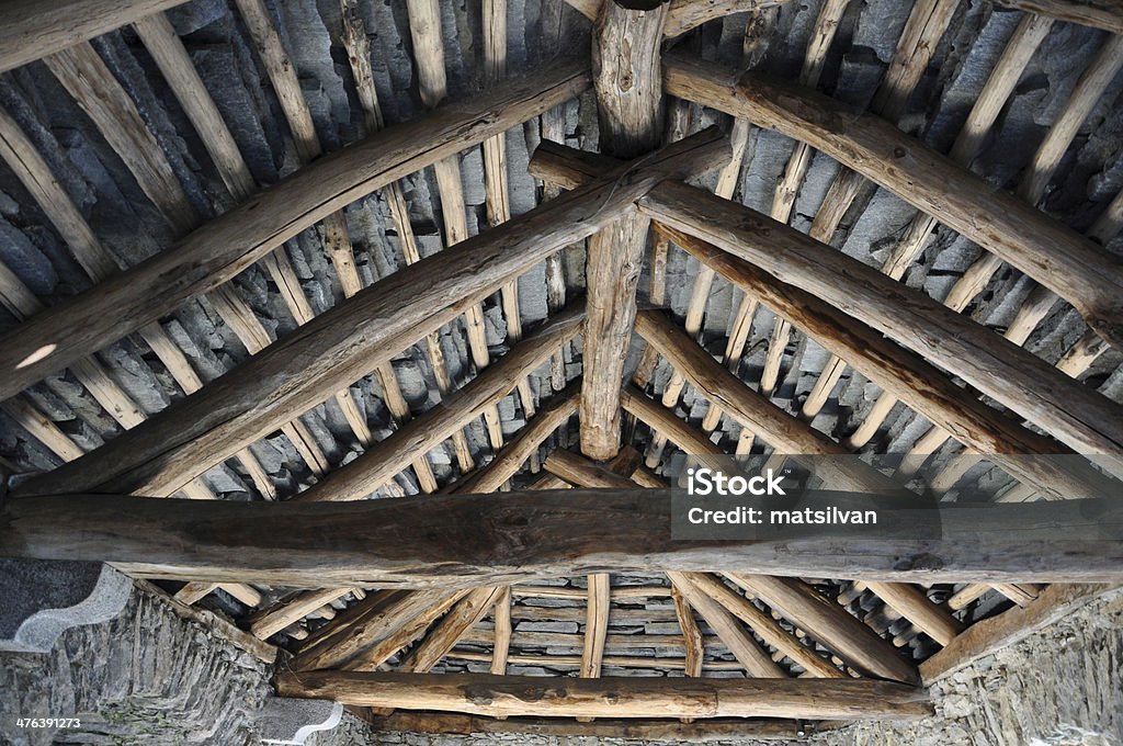 Rustic roof from under Old stone roof with wood beams from inside Directly Below Stock Photo
