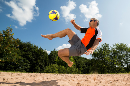 beachsoccer player in a bicycle kick