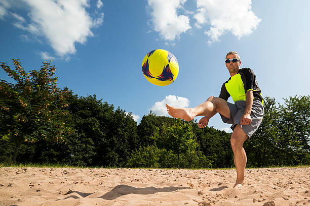 istock beach soccer player in a kick 476394137