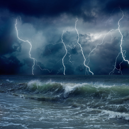 Dramatic nature background - lightnings in dark sky, stormy sea, big waves