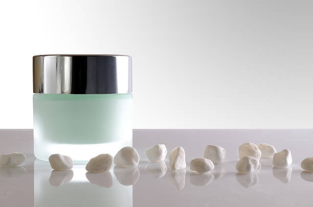 istock Cream jar closed and small white stones isolated 476396582