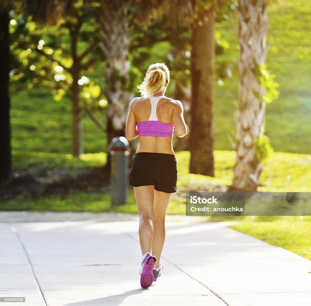 Donna Jogging nel parco - Foto stock royalty-free di Abbigliamento sportivo