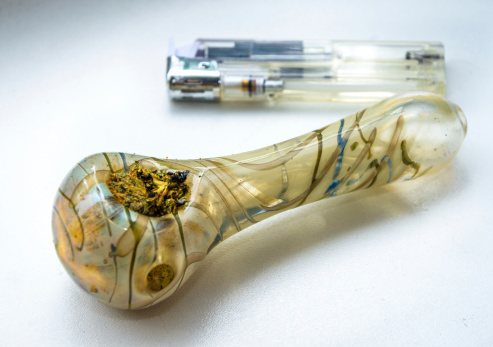 Isolated photo of marijuana pipe and lighter