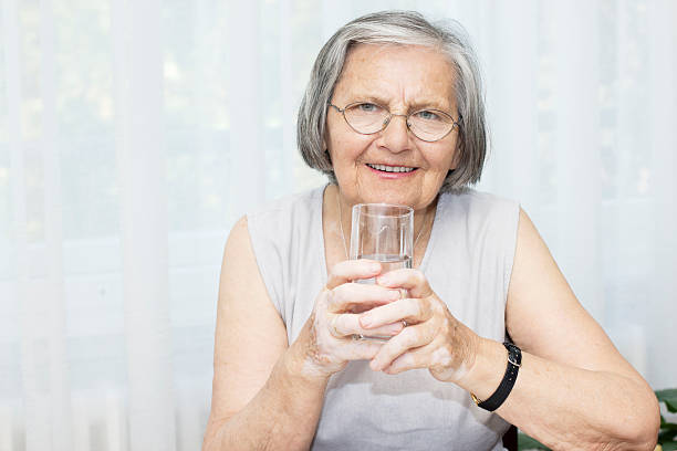 istock Senior woman drinking water 476398503