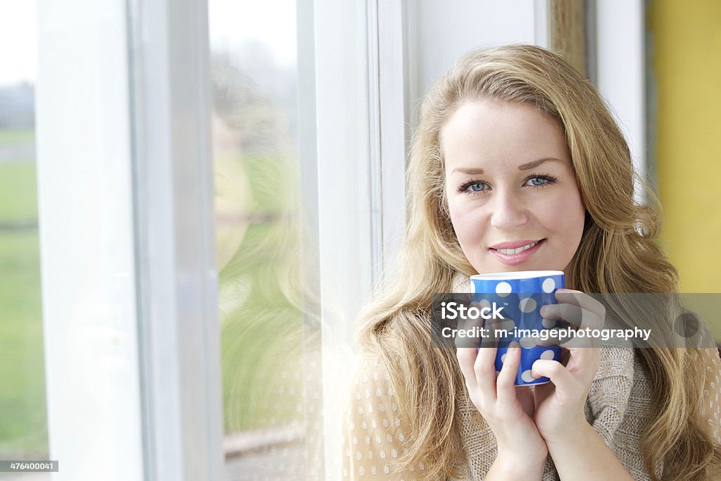 Tea break Close up portrait of a smiling young woman drinking cup of tea at home 20-29 Years Stock Photo