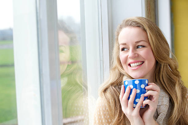 istock Young woman smiling with cup of tea 476400127