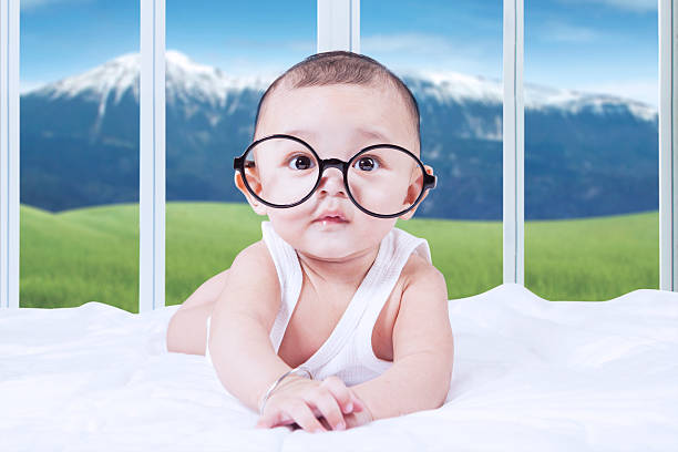 istock Adorable baby with glasses on bed 476403744