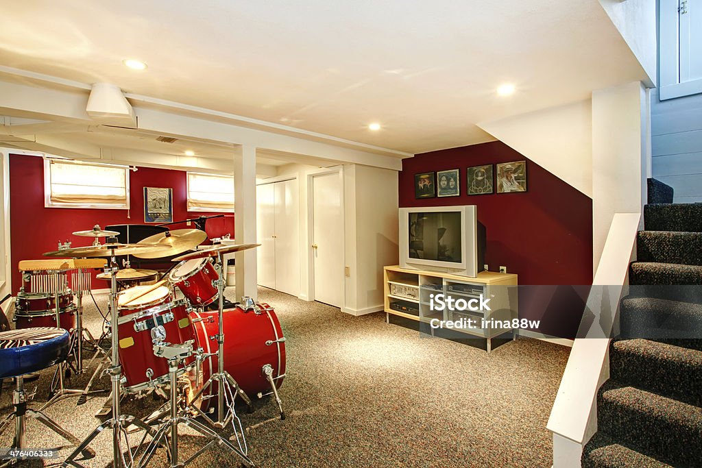 White and red rehearsal basement room White basement room with red and burgundy walls, carpet floor. Rehearsal room with drums Carpet - Decor Stock Photo