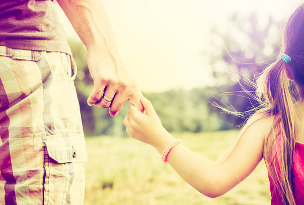 istock Father and daughter walking outdoors and holding hands closeup 476408858
