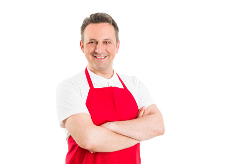 Confident hypermarket employee with arms crossed on white background