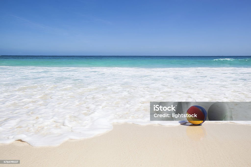 water ball at the beach travel background with a colorful water ball at the beach and a turquoise sea and a blue sky in the background Beach Ball Stock Photo