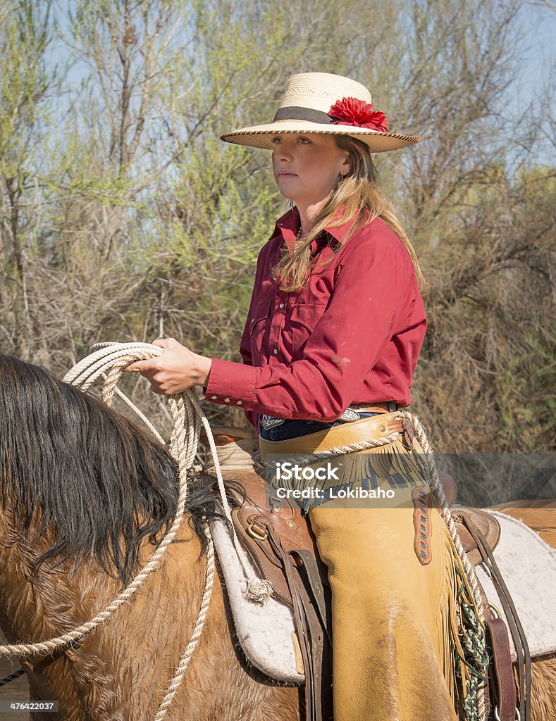 Cowgirl holding lasso on horse Adult Stock Photo