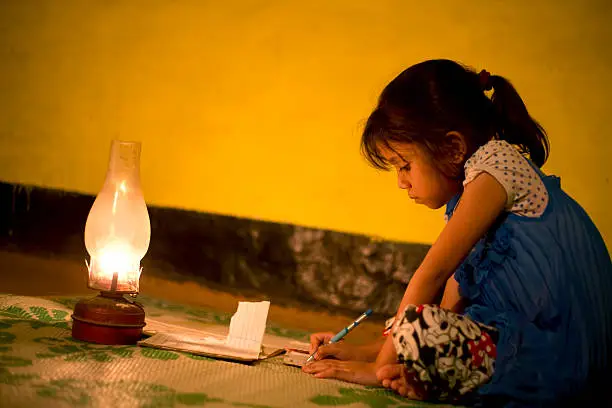 Village Girl studying in lighting lamp