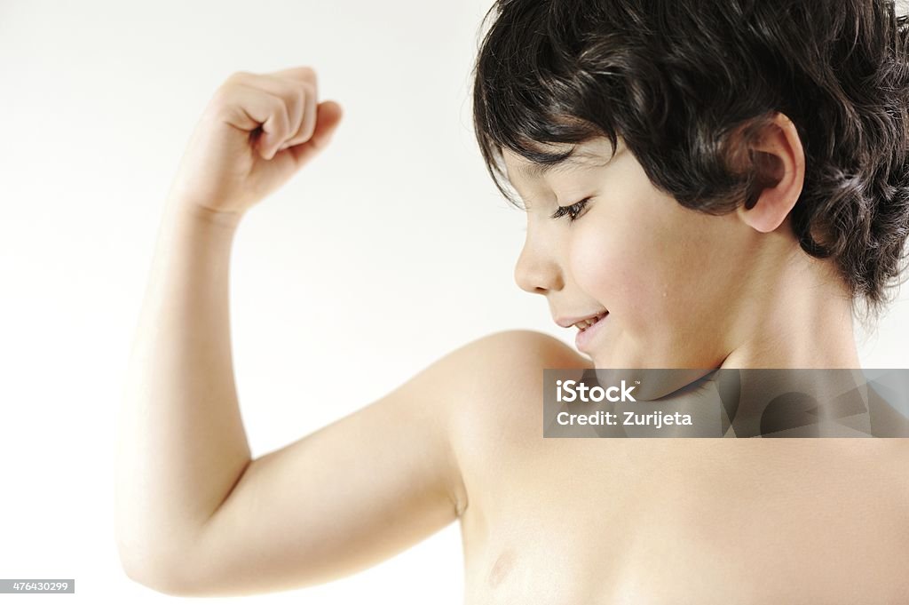 Bambino mostrando i muscoli del suo braccia - Foto stock royalty-free di A petto nudo