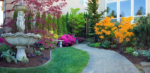 Frontyard Landscaping with Water Fountain and Brick Pavers Path with Azalea Flowers in Bloom
