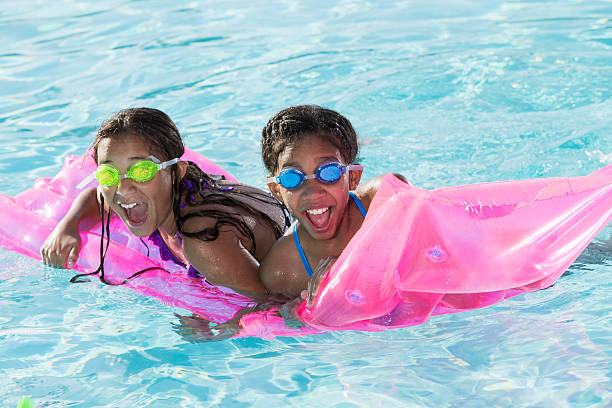 niñas jugando en la piscina. - early teens child swimming pool swimming fotografías e imágenes de stock