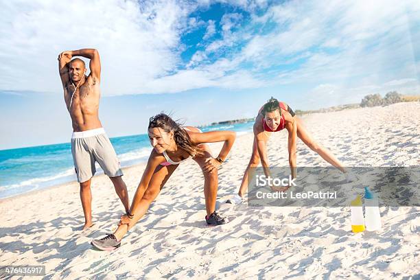 Trzy Atletic Osób Strething Na Plaży - zdjęcia stockowe i więcej obrazów 20-29 lat - 20-29 lat, Aktywny tryb życia, Bez koszulki