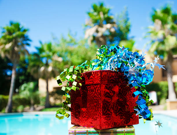 Gift box with ribbon by the swimming pool stock photo