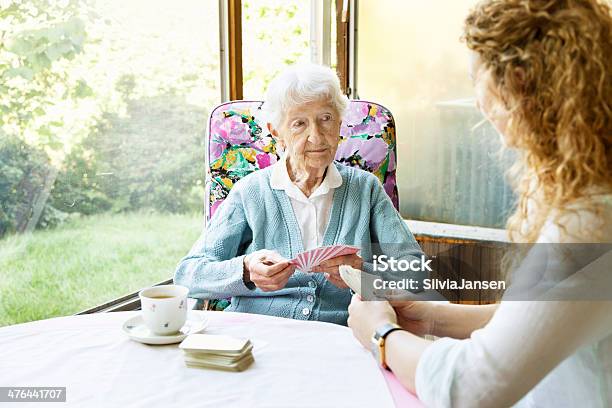 Donna Anziana E Caregiver Che Giocano A Carte - Fotografie stock e altre immagini di Nonna - Nonna, Giocare, Nipote femmina