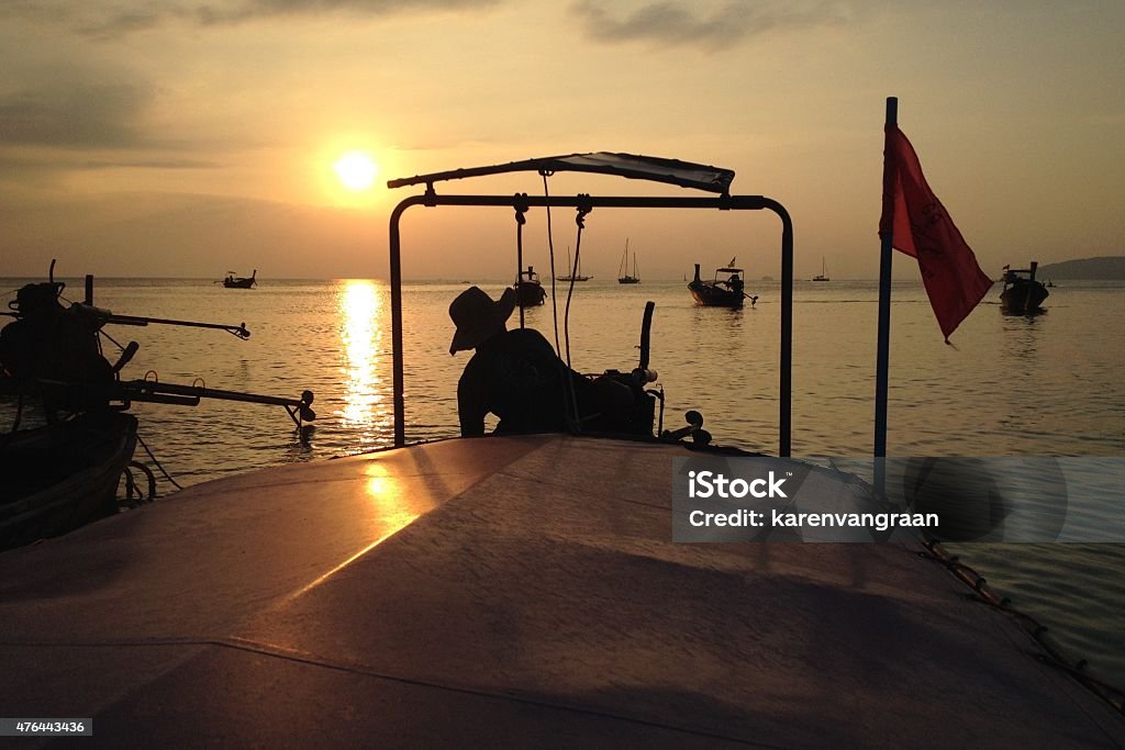 Longtail boat driver at dusk in Krabi Thailand Longtail Boat Driver at dusk in Thailand 2015 Stock Photo