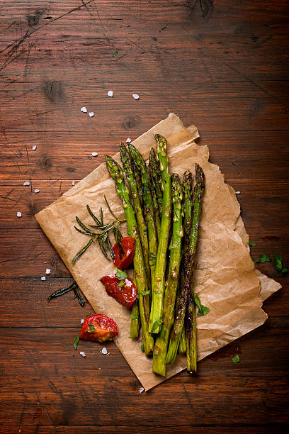 Roasted green asparagus on wooden background stock photo
