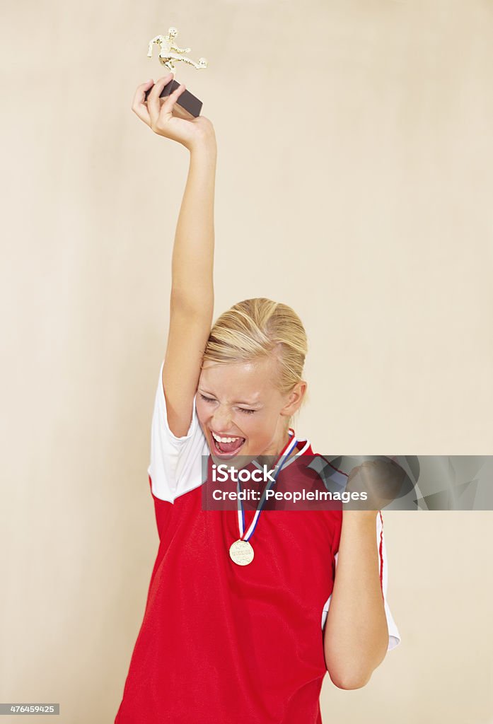 League MVP! Shot of a young woman dressed in a soccer uniform celebrating and holding up a trophy Most Valuable Player Stock Photo