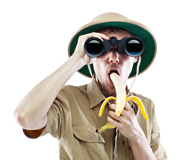 explorer con binocolo mangiare banane - men banana holding cut out foto e immagini stock