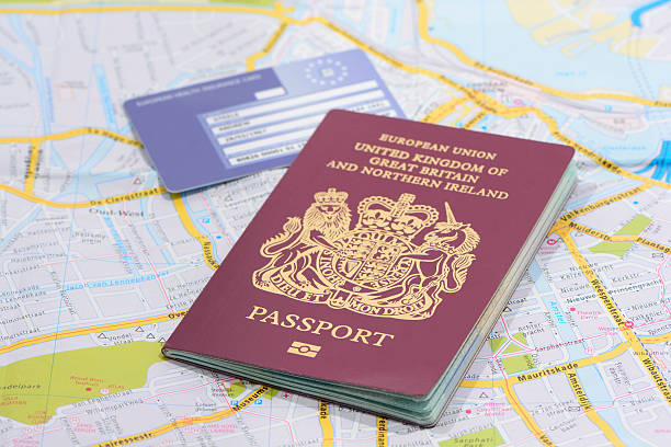 United Kingdom Passport and European Health Card London, United Kingdom - December 12, 2013: Studio shot of a United Kingdom biometric passports and a European Union Health Card on a road map, One passport standing up and the other laying flat. attraction studio photography stock pictures, royalty-free photos & images