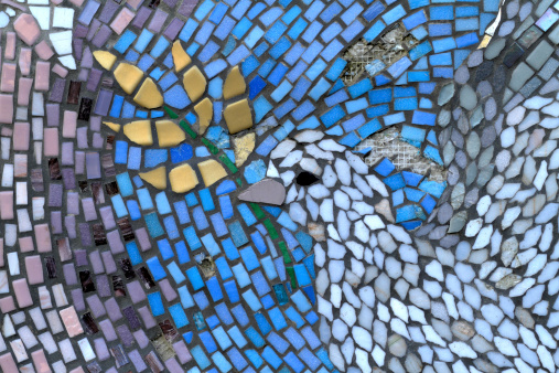 This mosaic plaque / wall mural is part of the Peace Garden in the Canons Recreation Ground, Mitcham in Merton, England. This detail highlights the use of tesserae, shaped and coloured pieces that go to form the mosaic. The plaque was unveiled as part of Peace Week in 2009 during the Peace Garden naming ceremony. The Merton Partnership has three main aims: bringing together diverse communities to participate in varied activities; developing a greater understanding and respect of each other; and contributing to the quality of life of the people of Merton. The whole mosaic plaque in the Peace Garden: .