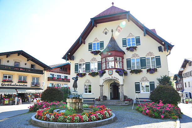 St. Gilgen, Austria - August 6, 2012: A Mozart statue in front of the city hall in St. Gilgen, the city where Mozart's mother born. Some souvenir stores around there, but only few tourists in morning.