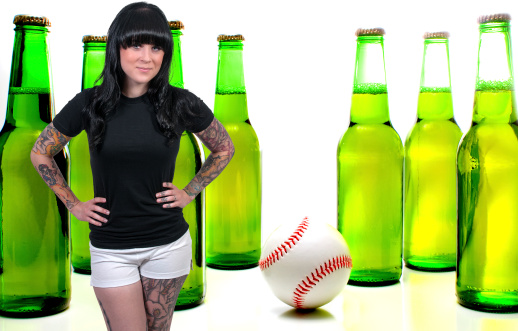 Beautiful young woman with beer and a baseball