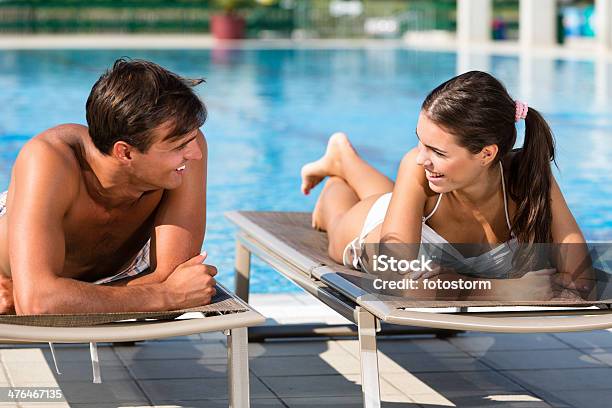 Young Couple Talking By The Swimming Pool Stock Photo - Download Image Now - Relaxation, Swimming Pool, Young Couple