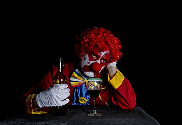 clown con faccia triste appoggiato sul tavolo a bere - clown mime sadness depression foto e immagini stock