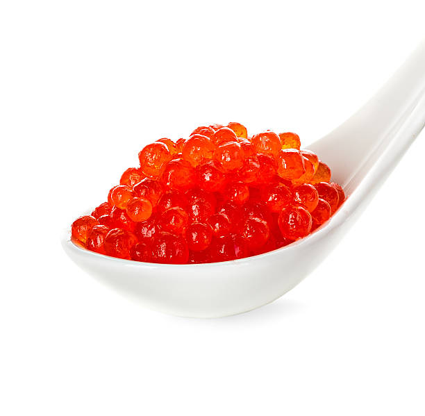 istock Red caviar in a spoon isolated on white background 476470750