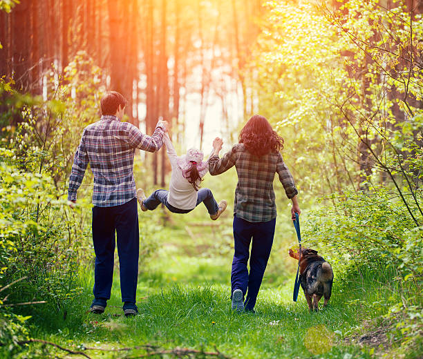 feliz família passear com o cachorro na floresta - child rear view running nature imagens e fotografias de stock