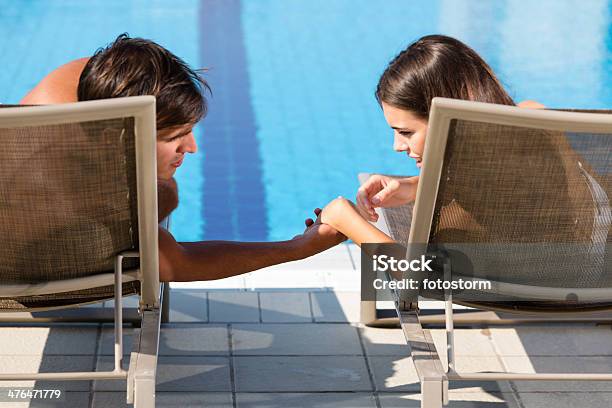 Hombre Y Mujer Descansando Junto A La Piscina Foto de stock y más banco de imágenes de Adulto - Adulto, Adulto joven, Agua