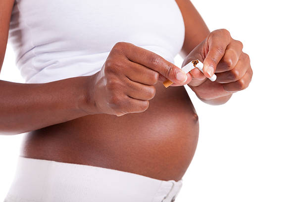 若い妊娠女性遮断、ブラックのシガレット-アフリカ人 - smoking issues cigarette breaking broken ストックフォトと画像