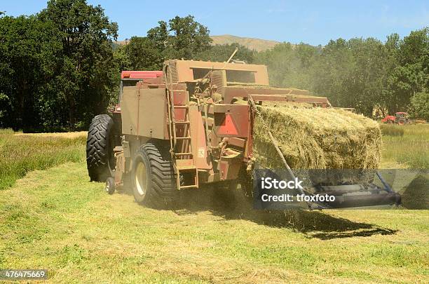 Photo libre de droit de Grand De Baler Tires De Tracteurs Et De Foin Dans Le Champ banque d'images et plus d'images libres de droit de Agriculture