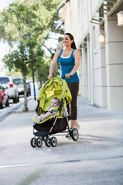 istock Woman pushing baby stroller 476476453