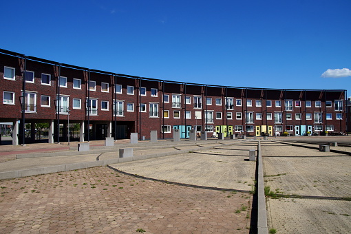 Modern houses in a row in a Dutch suburban city street (Almere Poort). Row building of houses traditional way of building homes in the Netherlands.