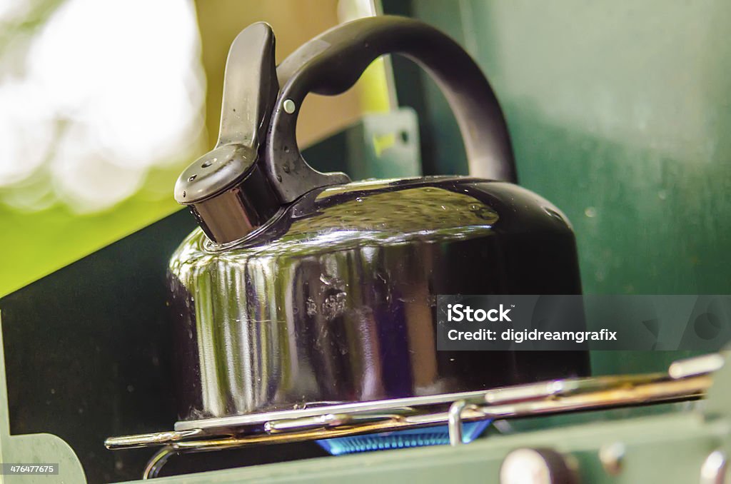 teapot on stove at camp teapot on gas stove at camping site Activity Stock Photo