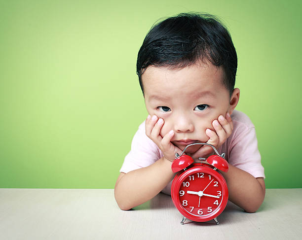 istock cute asia kid and clock 476478153