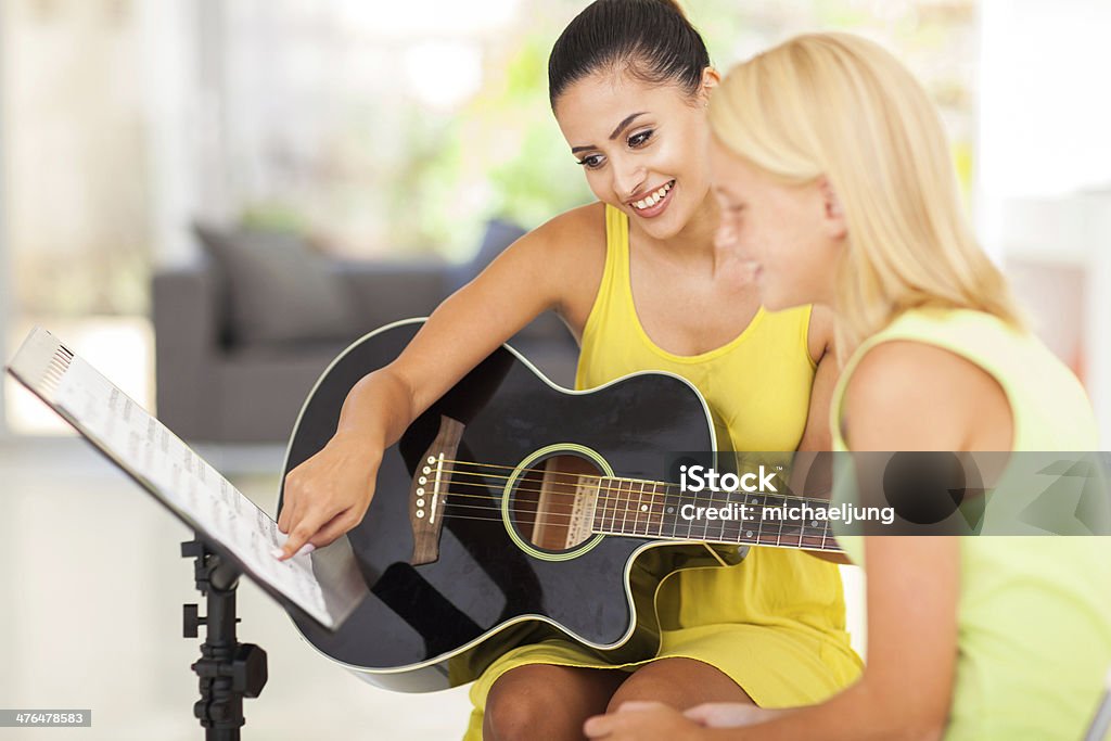 Los profesores de música tutoring Chica joven jugar guitarra - Foto de stock de Aprender libre de derechos