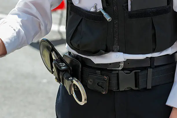 Closeup of a set of handcuffs in a leather holster on a British policeman's belt