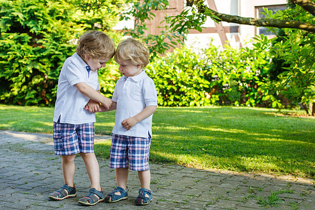 istock Two little sibling boys having fun outdoors in family look 476489749