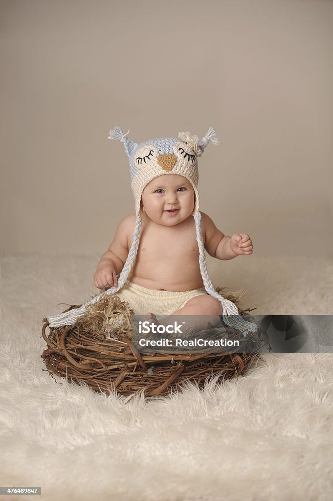 Szczęśliwy dziecko siedzi w Nest w Wełniana czapka - Zbiór zdjęć royalty-free (Niemowlę)