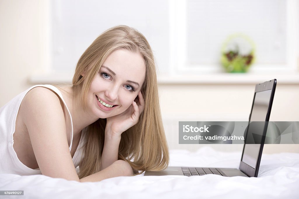 Girl In Bed A sexy woman lying on the bed with laptop Adult Stock Photo